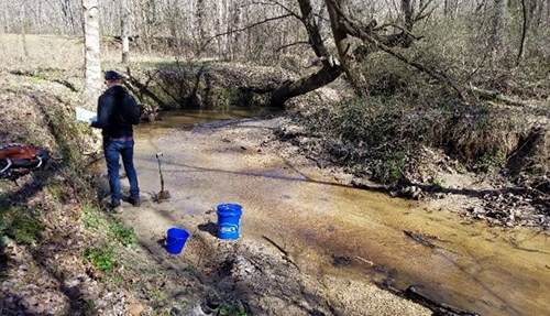 Aaron Barth collecting a stream sediment sample 